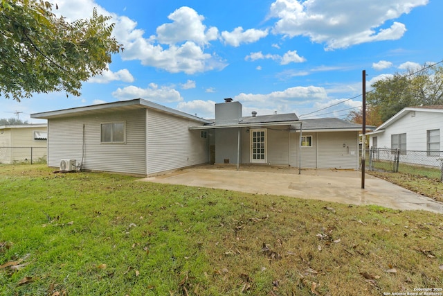 rear view of property featuring a chimney, fence, a patio, and a yard