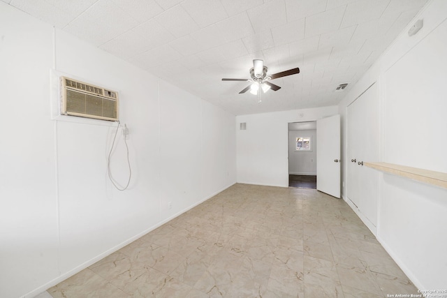 spare room with ceiling fan and an AC wall unit