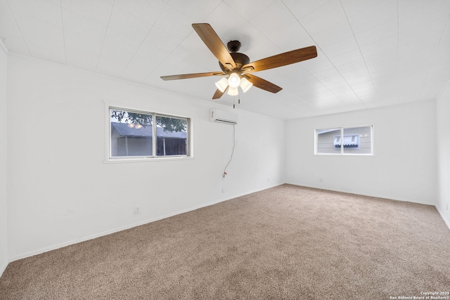 carpeted empty room with ceiling fan, a wall unit AC, and baseboards