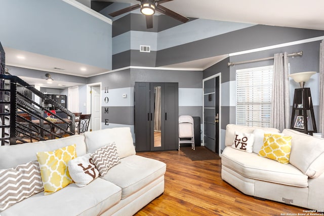 living room with visible vents, ceiling fan, stairway, ornamental molding, and wood finished floors