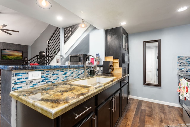 kitchen with dark wood-type flooring, light countertops, a sink, and backsplash