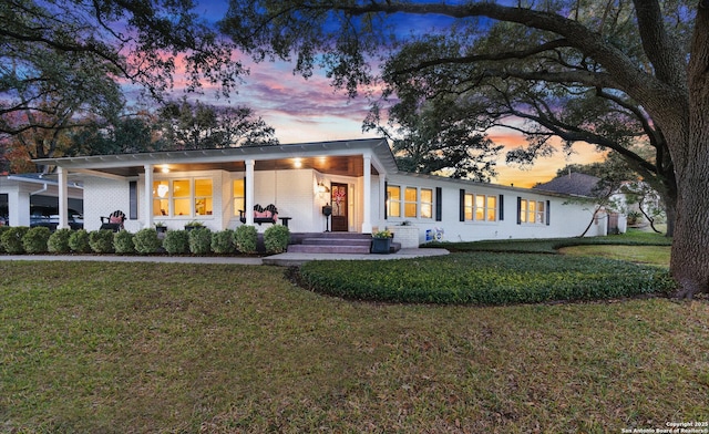 view of front of property featuring a lawn and brick siding