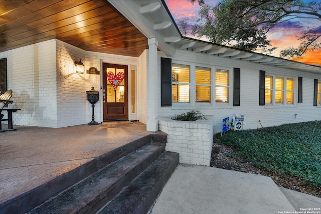 doorway to property with brick siding