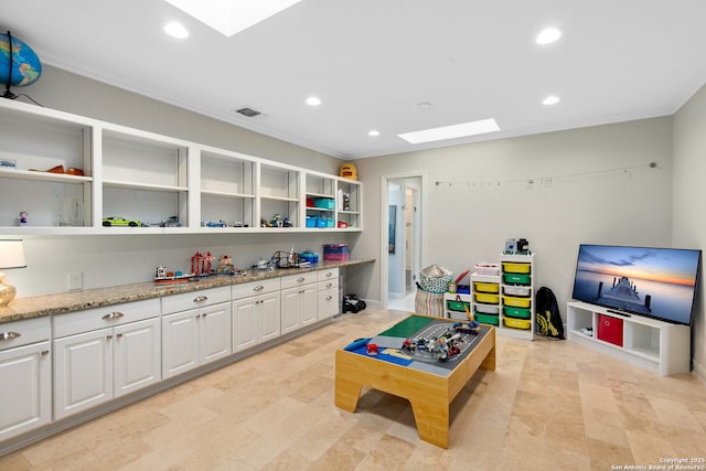 playroom featuring a skylight, visible vents, crown molding, and recessed lighting