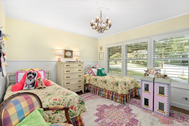 bedroom with a wainscoted wall, multiple windows, a chandelier, and crown molding