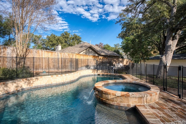 view of swimming pool featuring a pool with connected hot tub and a fenced backyard