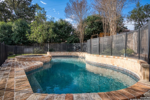 view of pool with a fenced backyard and a pool with connected hot tub