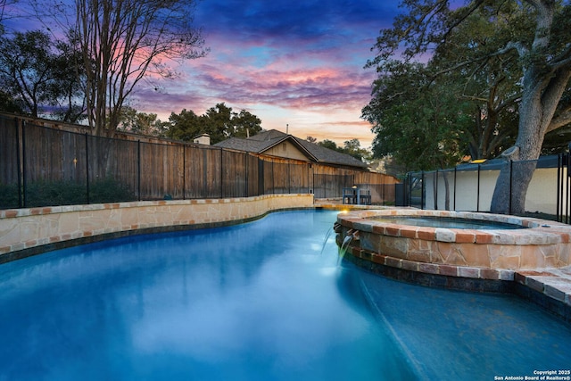 view of swimming pool featuring a fenced backyard and a pool with connected hot tub