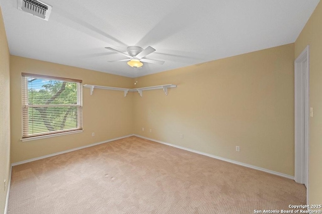 empty room with baseboards, visible vents, a ceiling fan, and light colored carpet