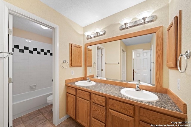 bathroom with tile patterned floors, a sink, toilet, and double vanity