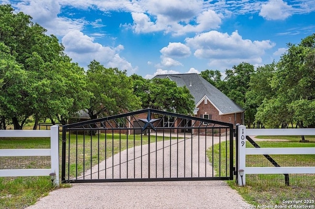 view of gate featuring fence and a yard