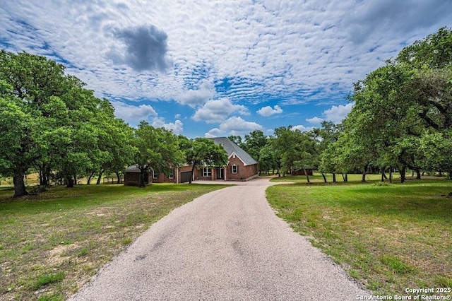 view of front of home with gravel driveway and a front yard