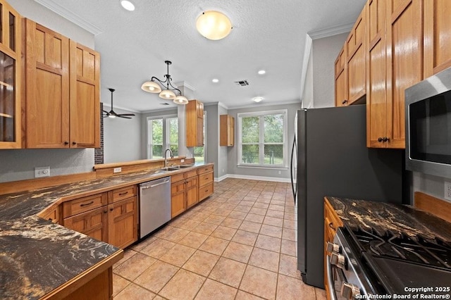 kitchen with glass insert cabinets, appliances with stainless steel finishes, ornamental molding, a peninsula, and a sink