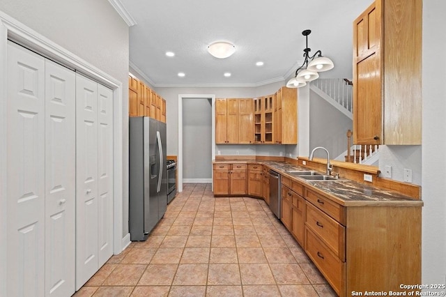 kitchen with pendant lighting, dark countertops, appliances with stainless steel finishes, glass insert cabinets, and a sink