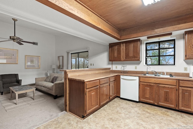 kitchen featuring white dishwasher, a sink, open floor plan, light countertops, and brown cabinetry