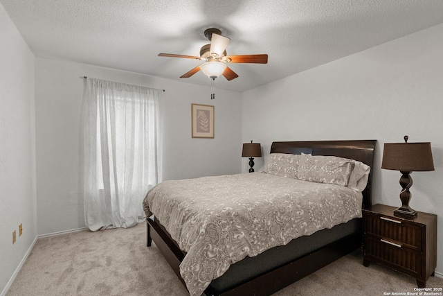 bedroom with light carpet, ceiling fan, a textured ceiling, and baseboards