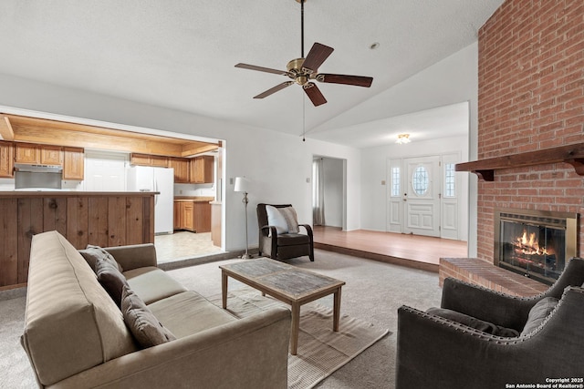 living room featuring lofted ceiling, a brick fireplace, light carpet, and ceiling fan