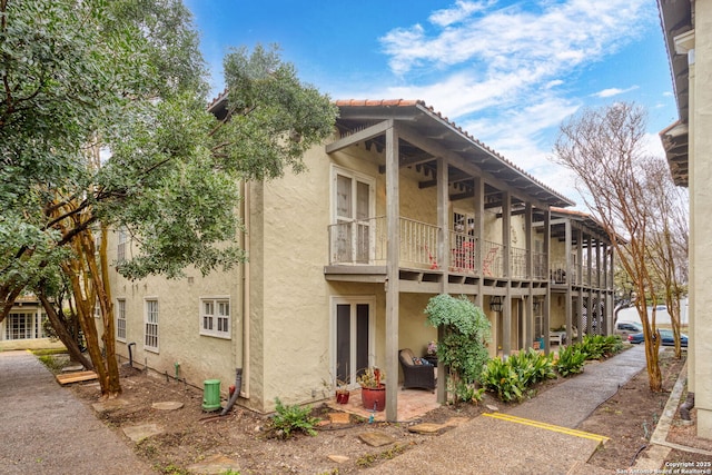 exterior space with a balcony and stucco siding