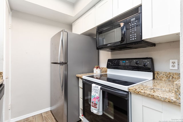 kitchen featuring light stone counters, light wood finished floors, appliances with stainless steel finishes, white cabinetry, and baseboards