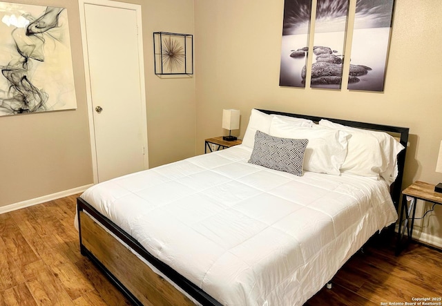 bedroom with wood finished floors and baseboards