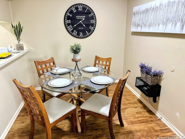 dining room featuring light wood-style floors and baseboards