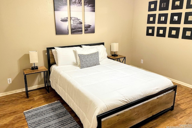 bedroom featuring baseboards and wood finished floors