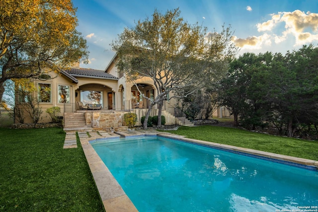 view of swimming pool featuring stairway, a lawn, and a fenced in pool