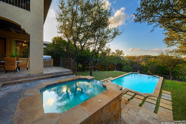 view of swimming pool with a patio, area for grilling, and a pool with connected hot tub