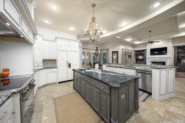 kitchen with a spacious island, high quality appliances, hanging light fixtures, gray cabinets, and white cabinetry