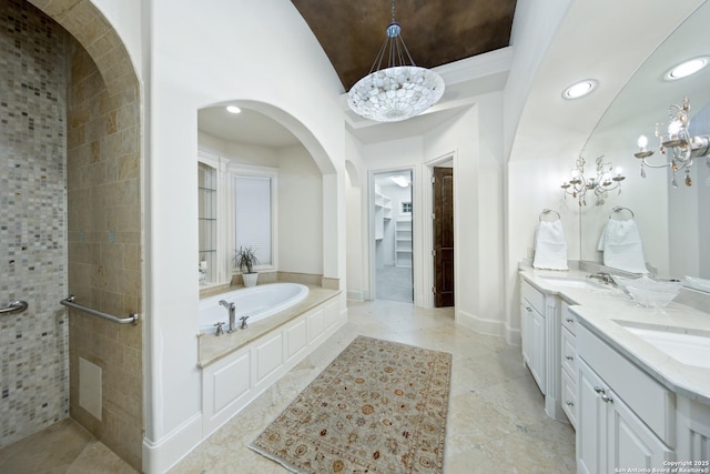 full bath featuring recessed lighting, a garden tub, a sink, and double vanity