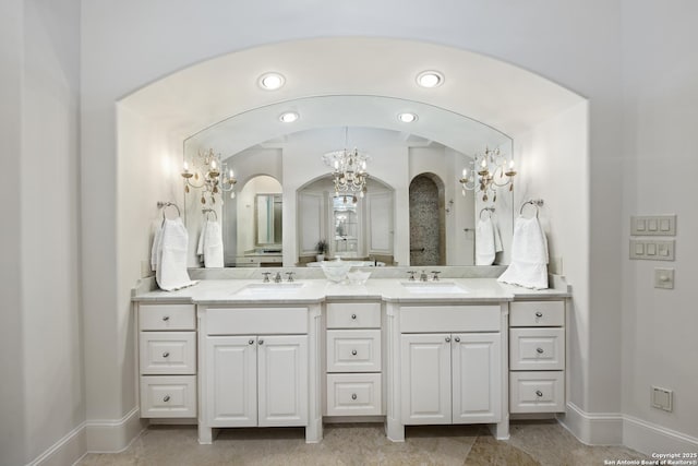 full bath featuring double vanity, a sink, and baseboards