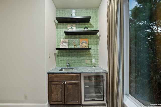 bar with wine cooler, backsplash, indoor wet bar, and a sink