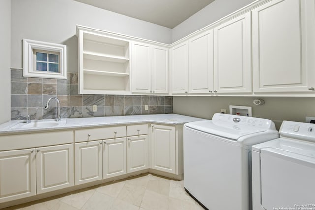 laundry room featuring cabinet space, marble finish floor, washer and clothes dryer, and a sink