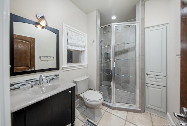 bathroom featuring a stall shower, baseboards, toilet, tile patterned flooring, and vanity