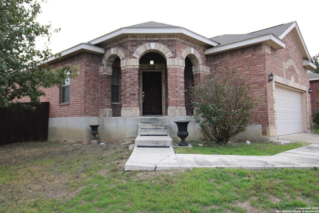 view of front of house with a garage, a front yard, concrete driveway, and brick siding