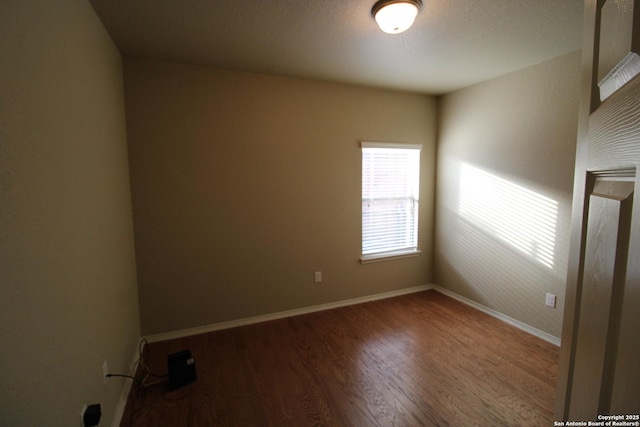 unfurnished room featuring baseboards and wood finished floors