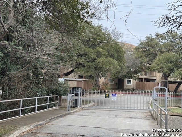 exterior space with curbs, a gated entry, and a gate