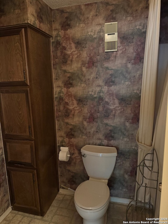 bathroom with baseboards, visible vents, and toilet