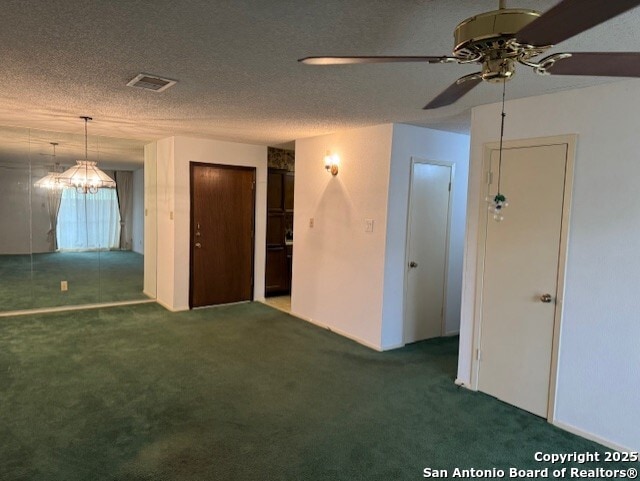 carpeted empty room with a ceiling fan, visible vents, and a textured ceiling