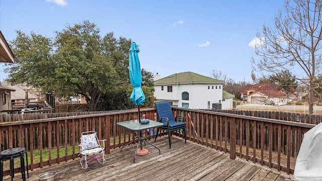 wooden deck with a fenced backyard