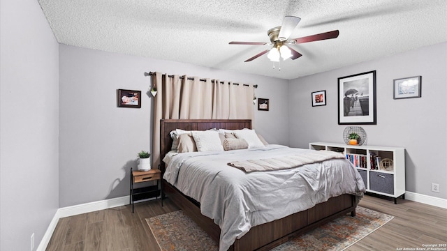 bedroom featuring dark wood-style flooring, ceiling fan, a textured ceiling, and baseboards