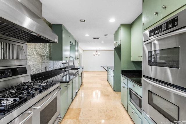 kitchen featuring island range hood, appliances with stainless steel finishes, dark stone counters, and green cabinetry