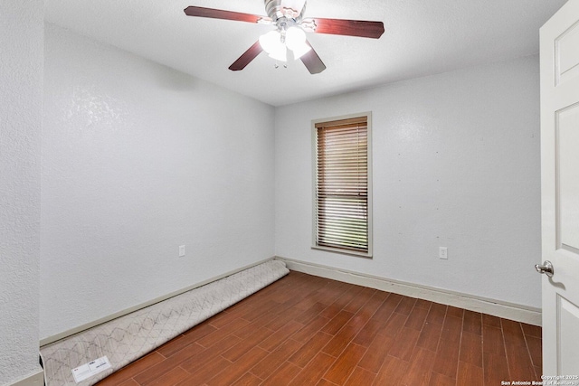 empty room with ceiling fan, baseboards, and wood finished floors