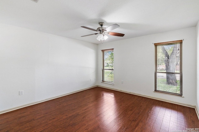 spare room with ceiling fan, wood finished floors, and baseboards