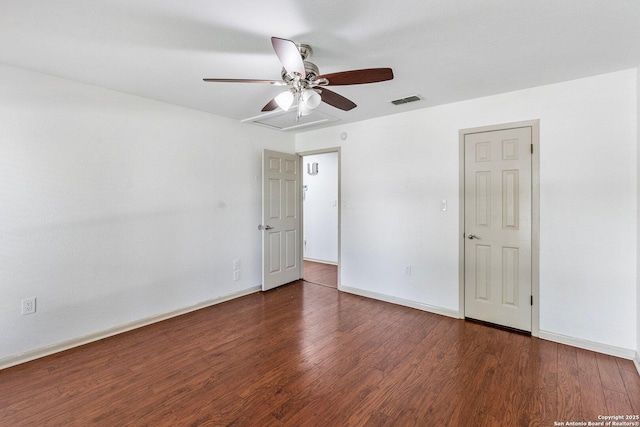 spare room featuring a ceiling fan, dark wood finished floors, visible vents, and baseboards