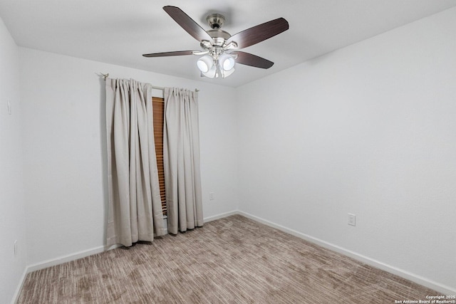 empty room featuring a ceiling fan and baseboards