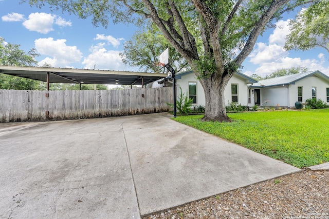 exterior space with a carport, a front yard, fence, and driveway