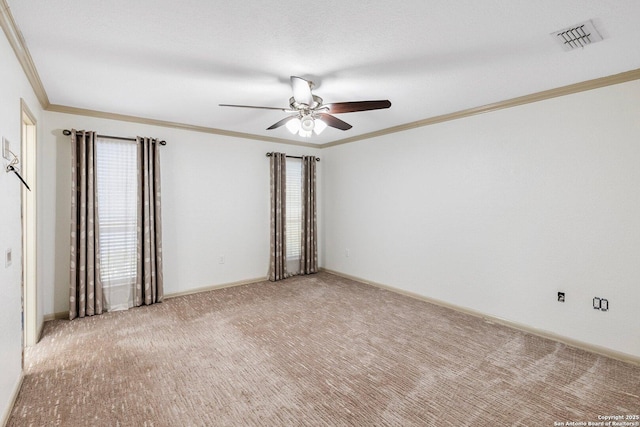 spare room featuring light carpet, baseboards, visible vents, a ceiling fan, and ornamental molding