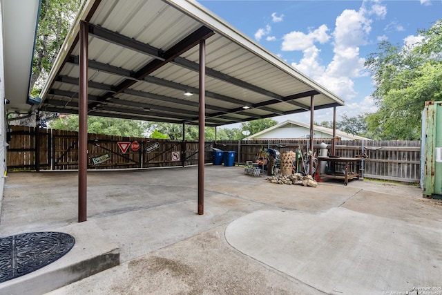 view of parking / parking lot with a carport and a fenced backyard