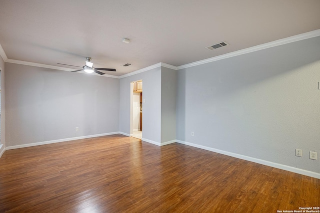 empty room with crown molding, a ceiling fan, wood finished floors, baseboards, and visible vents